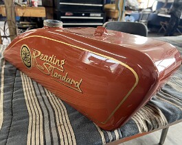 Restored gas tank with painted logo and pinstripe (right side).